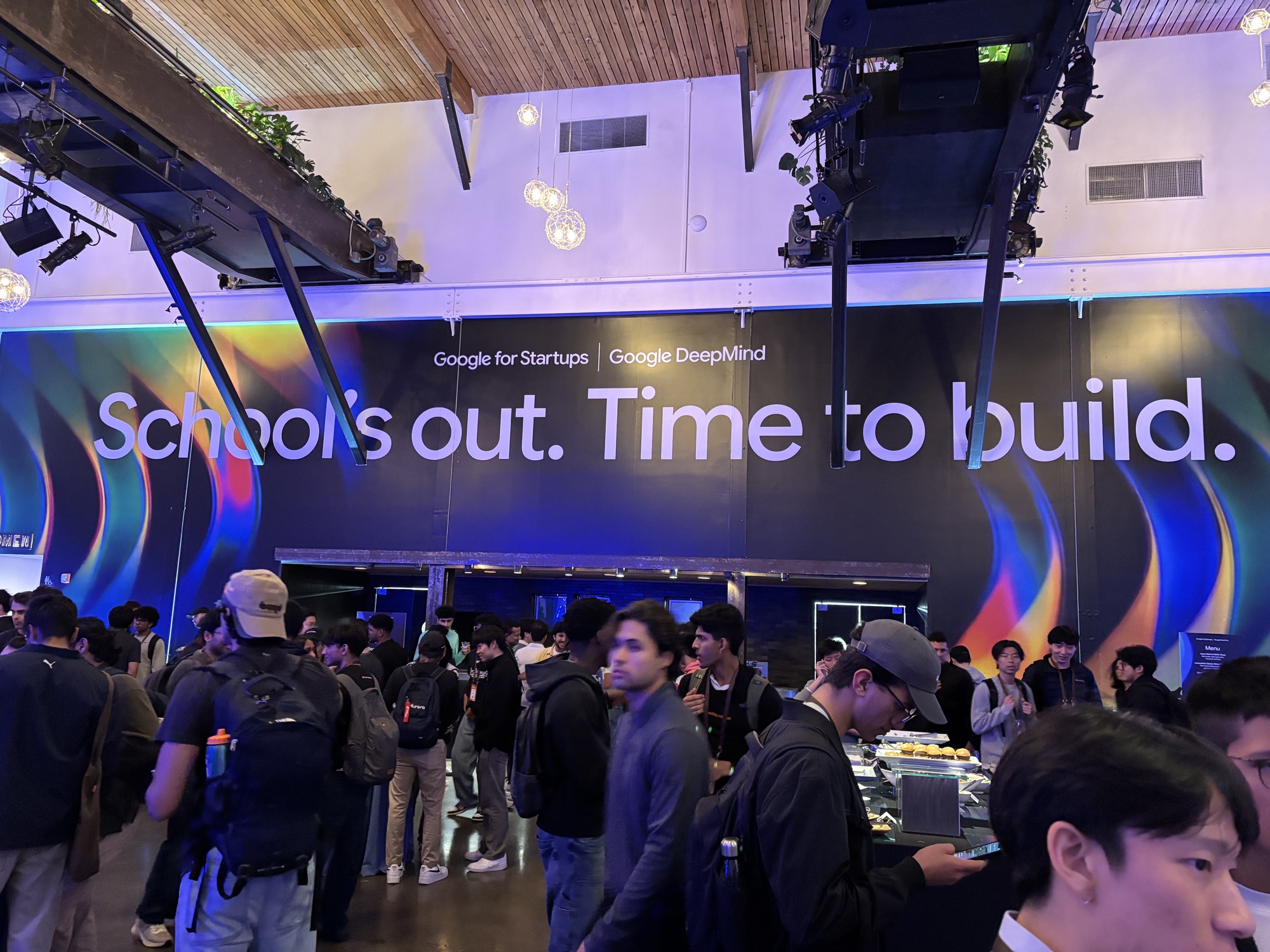 inside the Google DeepMind afterparty with a big wall reading School's out. Time to build.