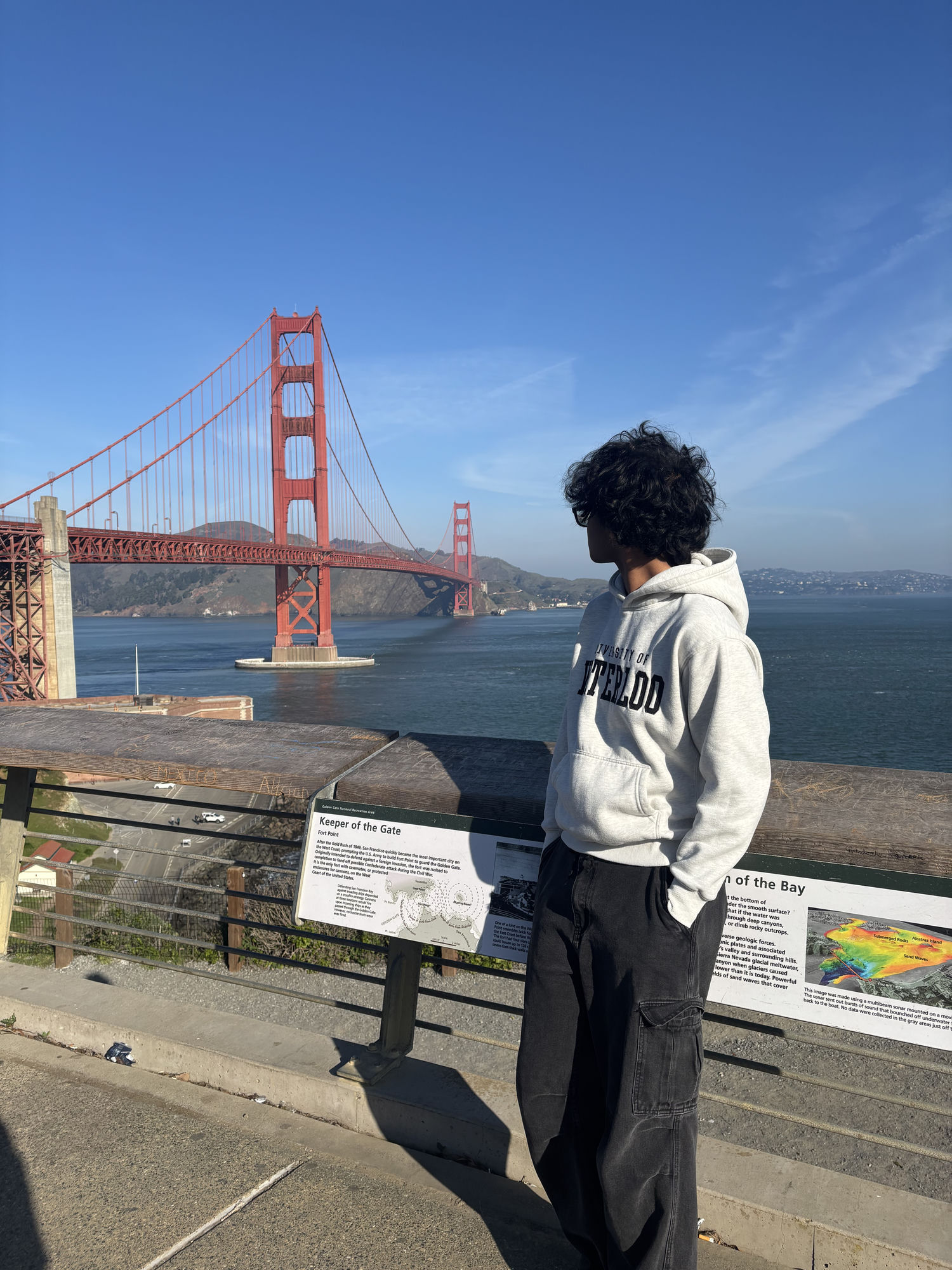 me standing in front of the Golden Gate Bridge in a University of Waterloo hoodie