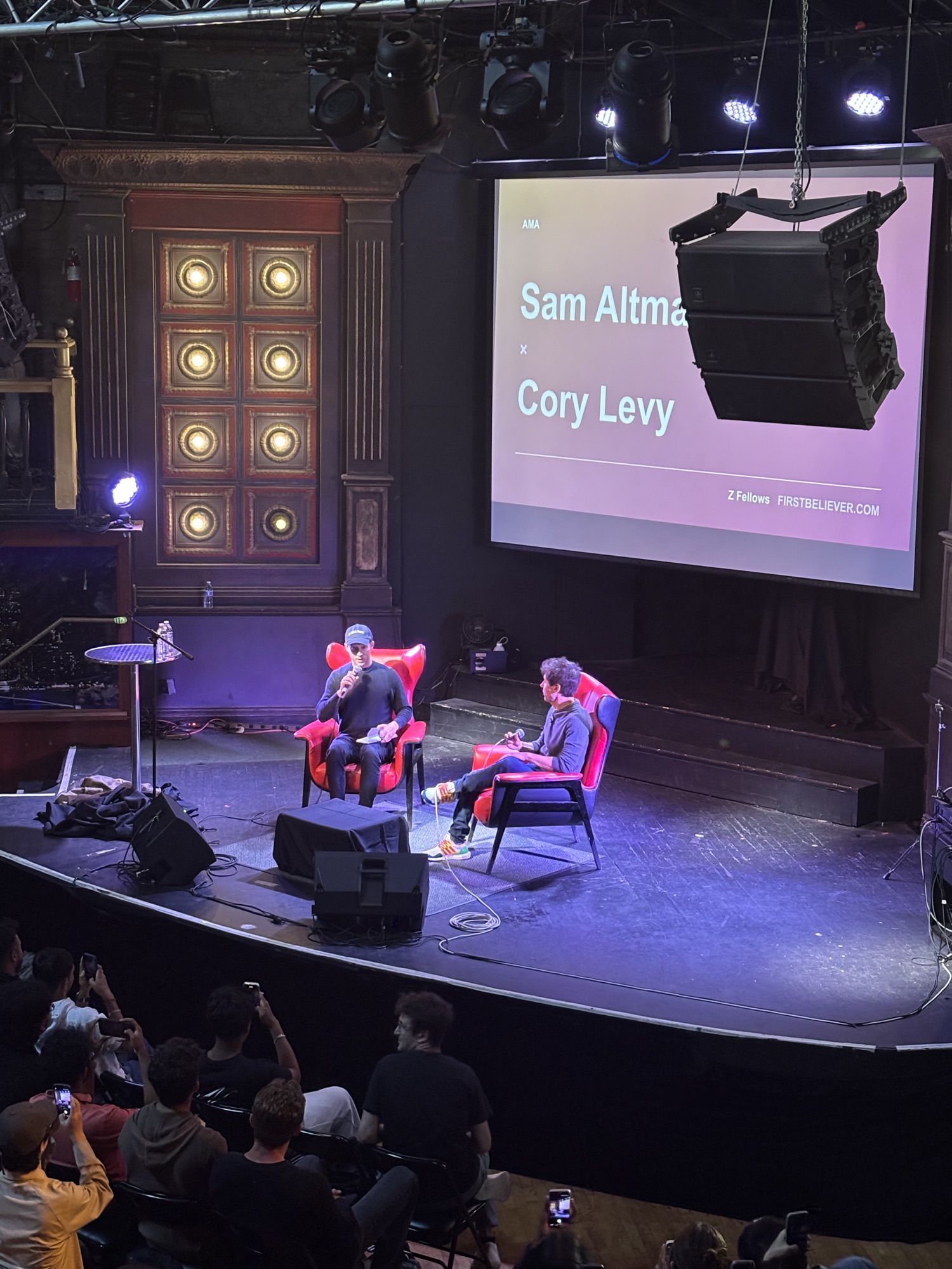Sam Altman and Cory Levy on stage in red chairs during an AMA at Internapalooza
