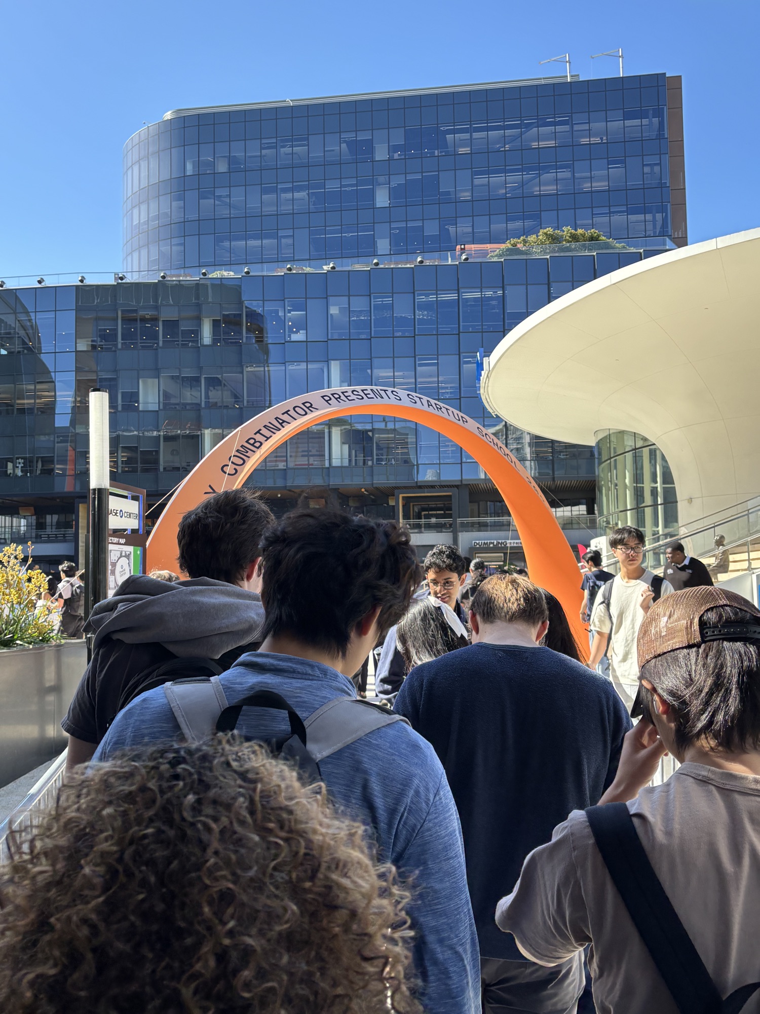 an orange Y Combinator Startup School 2026 arch over the crowd entering the Chase Center plaza